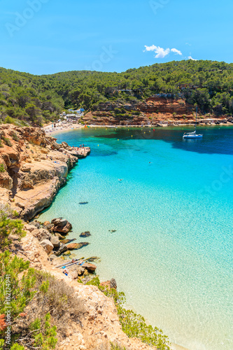 View of beautiful beach in Cala Salada bay famous for its azure crystal clear sea water, Ibiza island, Spain