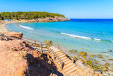 Wooden steps to Cala Nova beach on sunny summer day, Ibiza island, Spain