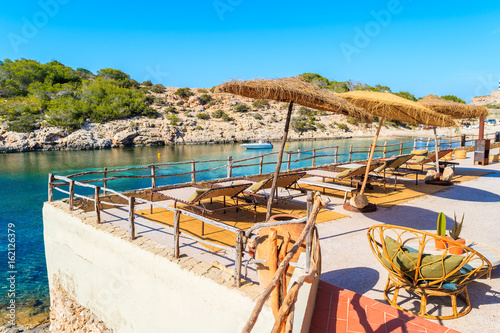 Coastal bar terrace overlooking Cala Portinatx bay, Ibiza island, Spain