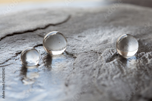 Water pearls on wet stone surface
