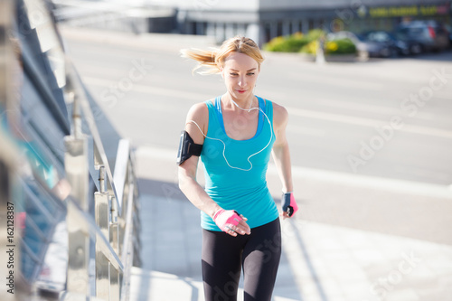 Sporty female jogger running and training outside in nature