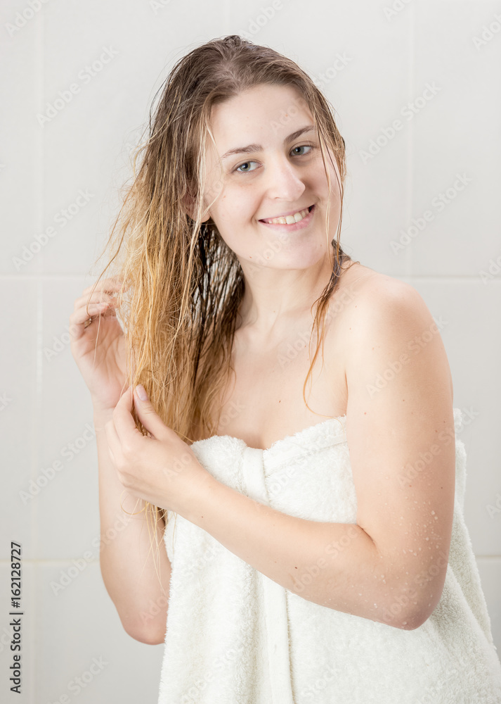 Portrait of smiling woman with long hair covered in towel Portrait of smiling woman with long hair covered in towel