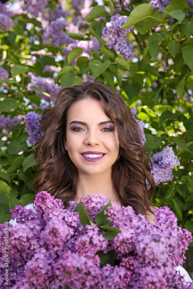 Beautiful young woman with lilac make up in spring garden Beautiful young woman with lilac make up in spring garden