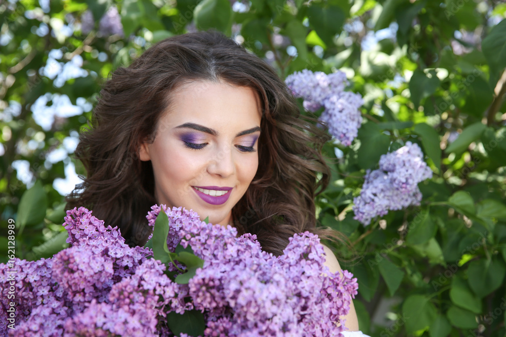 Beautiful young woman with lilac make up in spring garden Beautiful young woman with lilac make up in spring garden