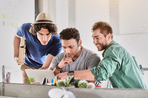 Skillful male coworkers using modern computer
