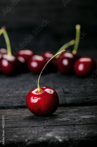 Cherries on a black table.. Natural wooden burnt table. Fresh food concept. Fruit. Summer time 