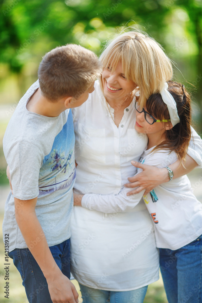 Mother talks heart to heart with her adult children on a walk in the forest: a boy and a girl teenagers Mother talks heart to heart with her adult children on a walk in the forest: a boy and a girl teenagers
