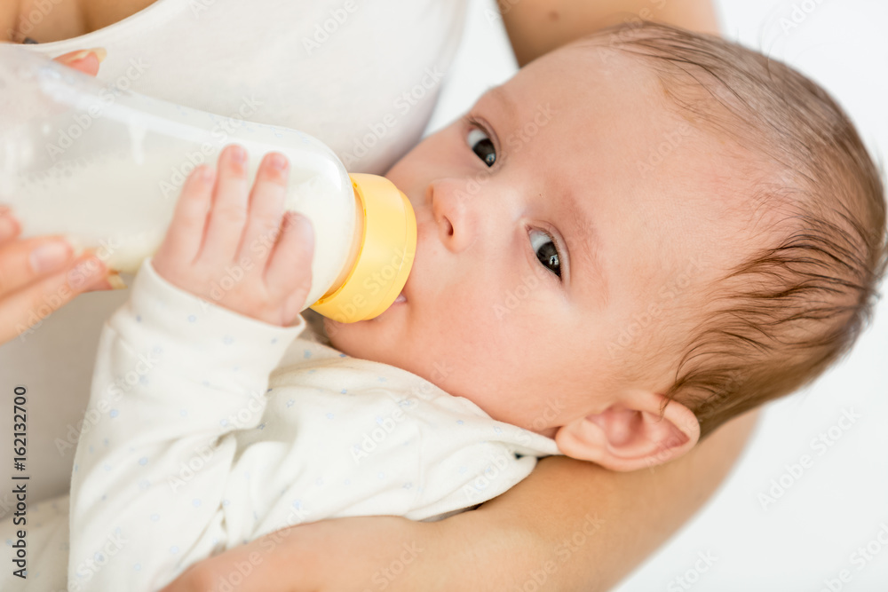 Mother feeding her 3 months old baby from bottle Mother feeding her 3 months old baby from bottle