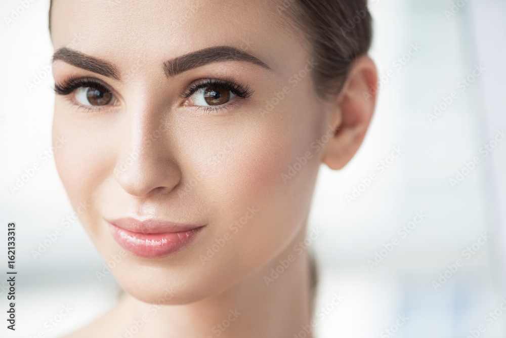 Fototapeta premium Radosna piękna dziewczyna z doskonałymi kosmetykami twarzy