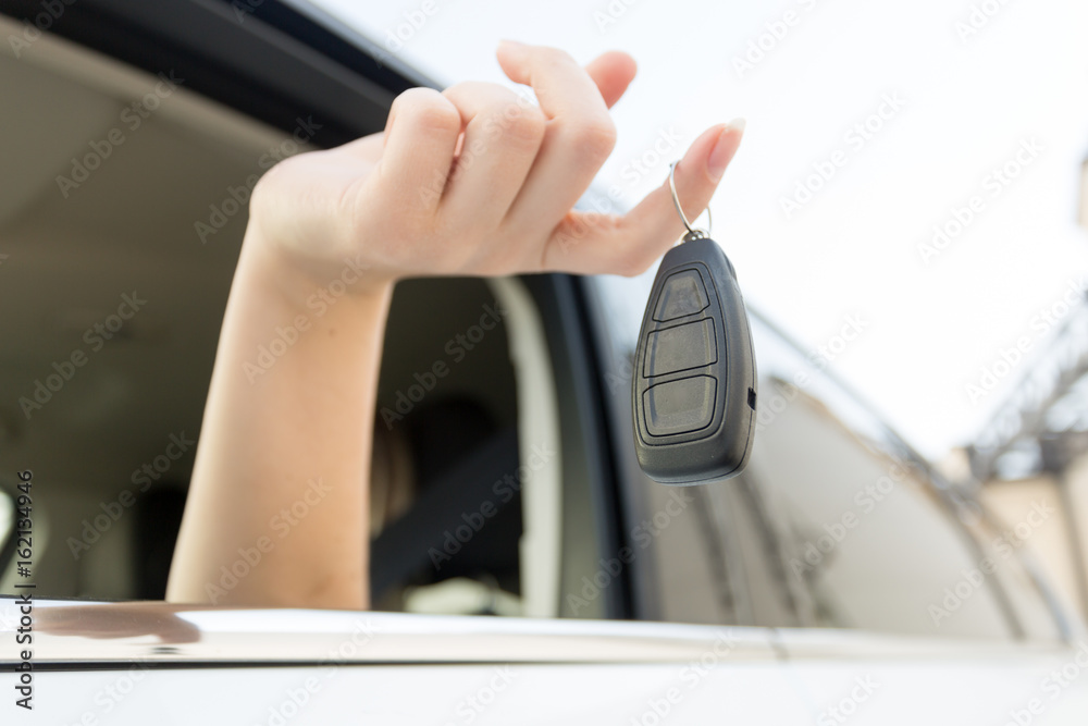 Closeup of car keys hanging on female finger Closeup of car keys hanging on female finger