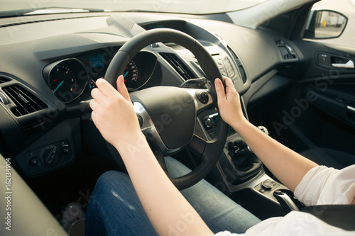 Closeup photo of young woman driving car and looking on the road