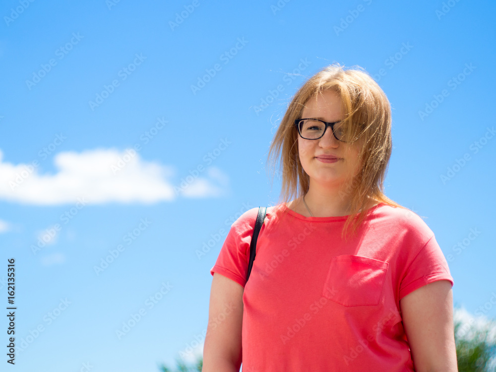 girl with glasses on the background of blue sky