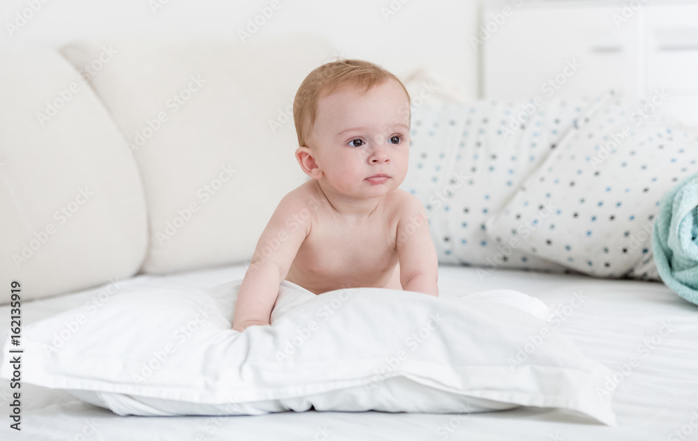 Adorable baby boy relaxing on pillow