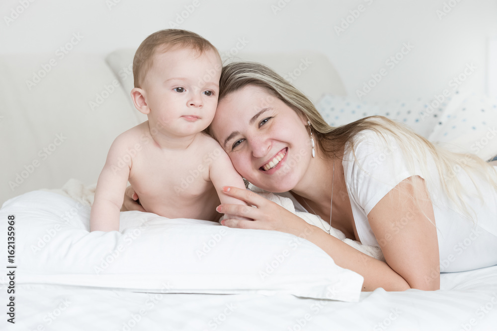 Happy smiling baby boy and mother lying on pillow and looking at camera Happy smiling baby boy and mother lying on pillow and looking at camera