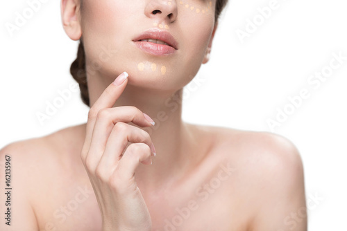 Attractive young lady using foundation