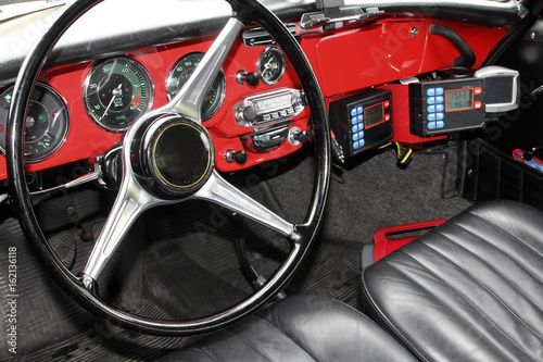 Steering wheel and red dashboard in a retro car