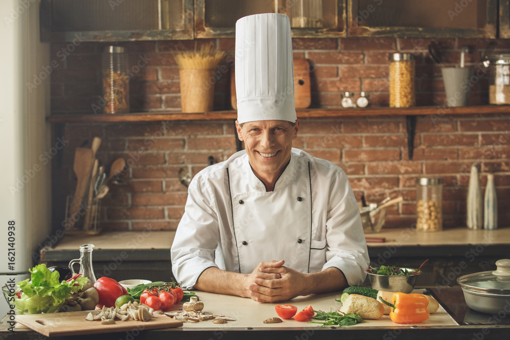 Mature man professional chef cooking meal indoors Mature man professional chef cooking meal indoors