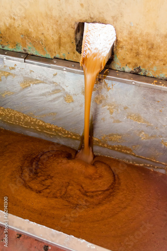 Detail of pourin of sugar cane juice. This is a part of a process of producing panela (unrefined whole cane sugar) in Colombia photo