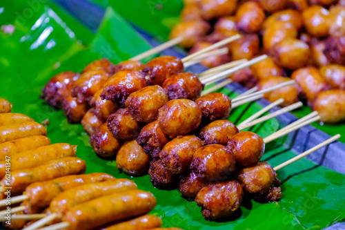 thai sausage with stick sale on banana leaf at the street market