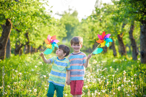 Two happy children playing in garden with windmill photo