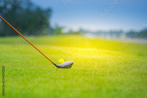 Golf club and ball in grass, Lens flare on sun set evening time, Selective focus