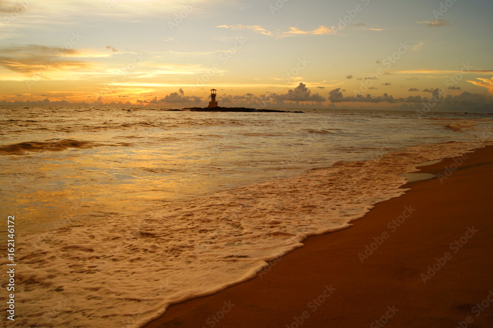 Lighthouse and beautiful colorful sunset over the Andaman sea in Khao Lak, Thailand.