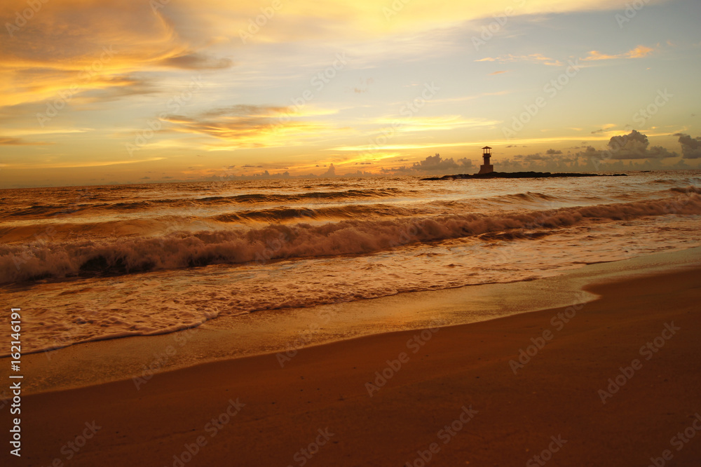Lighthouse and beautiful colorful sunset over the Andaman sea in Khao Lak, Thailand.