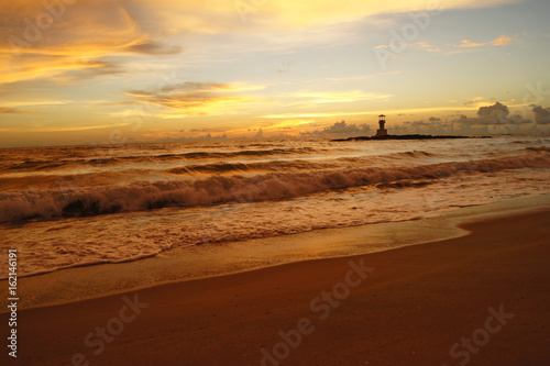 Lighthouse and beautiful colorful sunset over the Andaman sea in Khao Lak, Thailand.