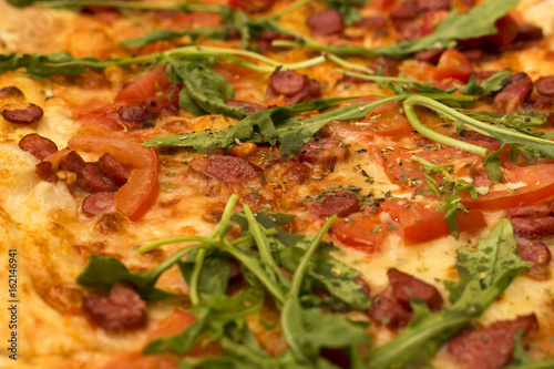 Appetizing pizza with sausage and arugula