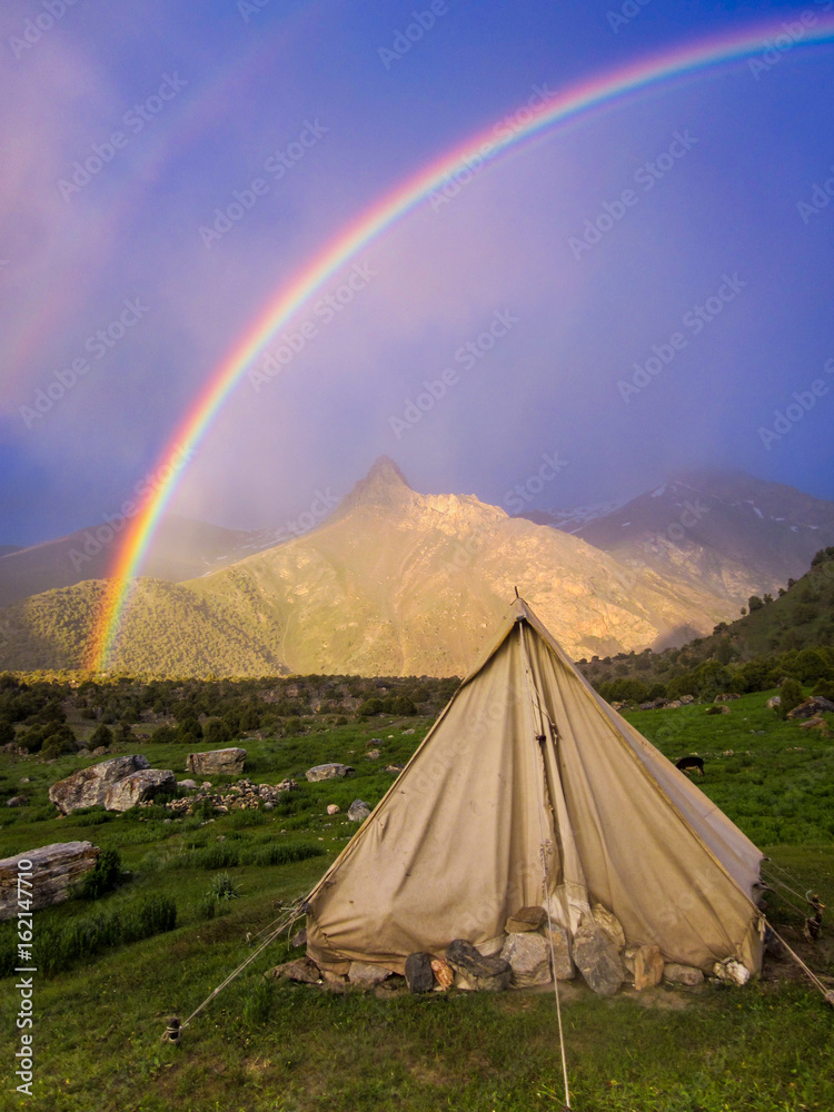 A tent and a rainbow in the Fann Mountains