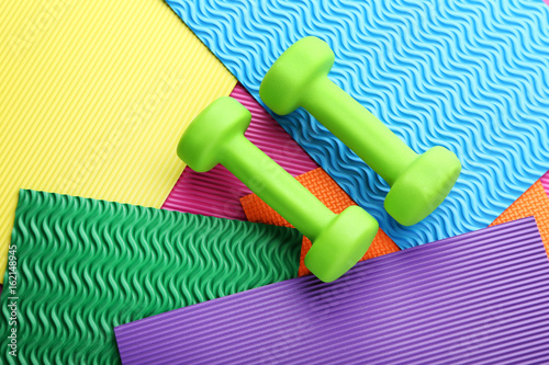 Green dumbbells on colorful background
