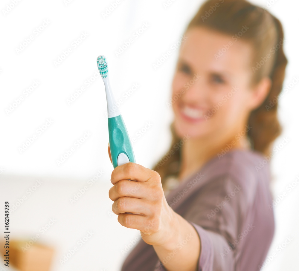 Closeup on toothbrush in hand of young woman Closeup on toothbrush in hand of young woman