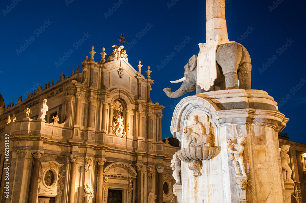 The famous lava stone elephant in the main square of Catania, Sicily, with a view of St. Agatha church