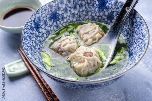 Traditional Chinese Wan Tan Soup as close-up in a bowl photo