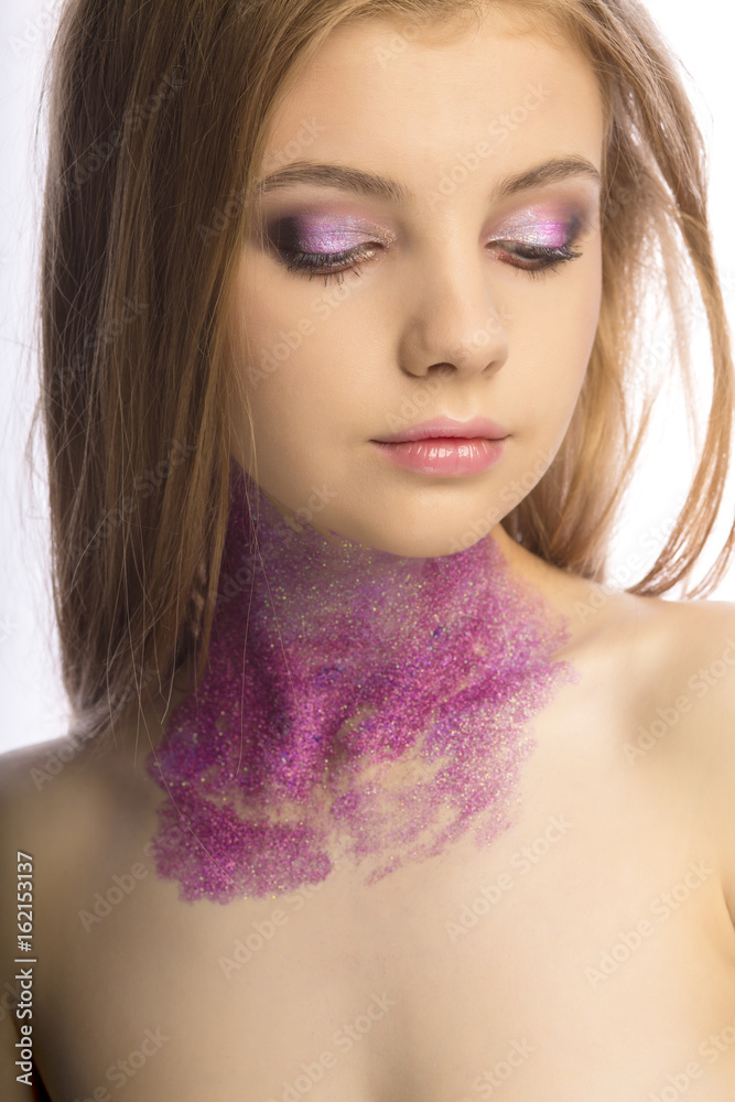 Fashion blonde model with art makeup posing at studio over a white background Fashion blonde model with art makeup posing at studio over a white background