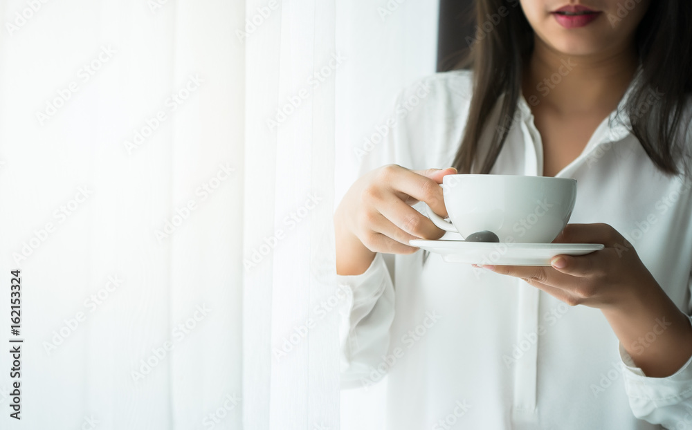Asian Woman holding a mug of coffee in the morning on the weekend in Relax and weekend concept. Asian Woman holding a mug of coffee in the morning on the weekend in Relax and weekend concept.