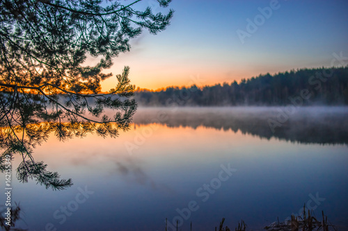 Sunrise on a small lake near forest