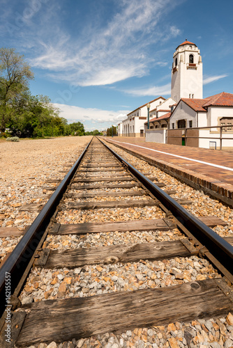 Train tracks and a local train depot with cloudy sky