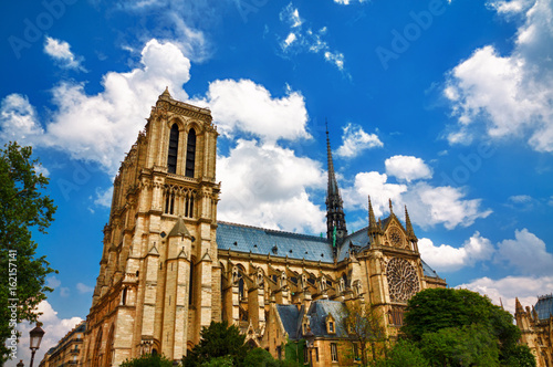 A high dynamic range shot of the beautiful Notre Dame Cathedral in Paris, France against a blue sky with volumetric clouds