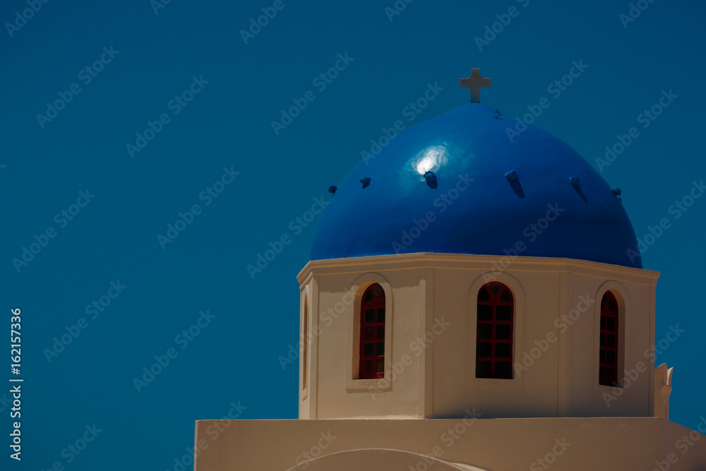 Postcard vacation and holiday shot of a white dome Orthodox church in the Greek island of Santorini.