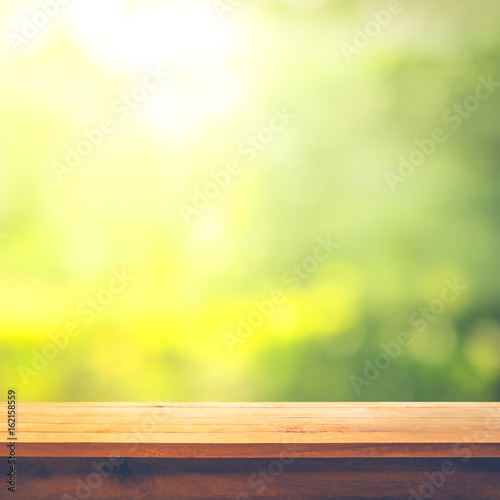 Wood table top on blur abstract green from garden in the morning background.For montage product display or  key visual layout © hakinmhan
