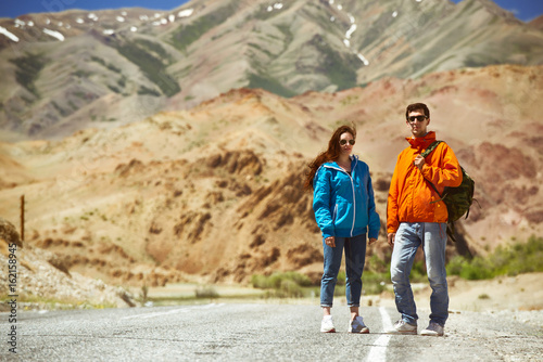 Couple backpackers on mountain road