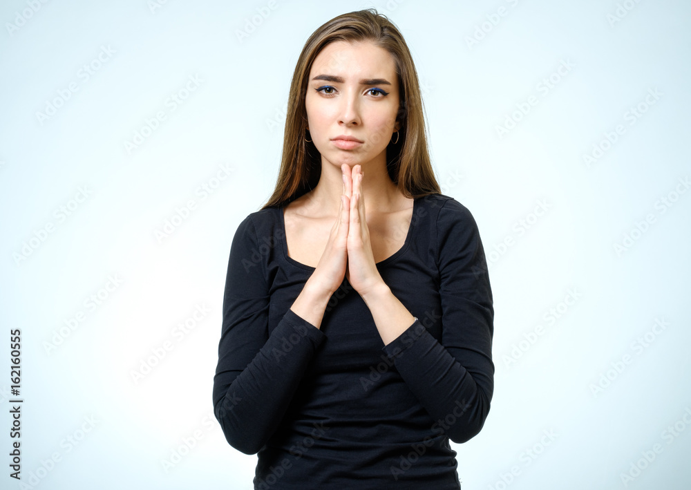 Closeup portrait of a young woman praying isolated Closeup portrait of a young woman praying isolated