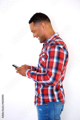 Side portrait handsome black young man looking at cellphone © mimagephotos