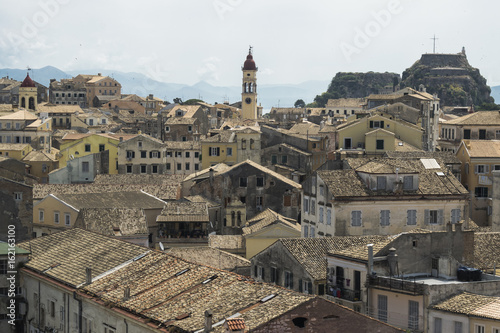 View on Corfu city or Kerkyra from New Fortress. Skyline of typical houses of old town. Tourist attraction and popular vacation destination. Sunny day in beginning of June.