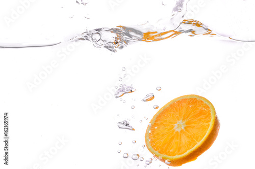 orange slice in water splash on white background