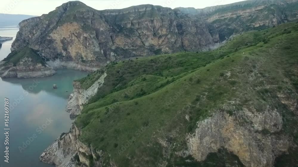Dagestan. River Canyon. Stone Cliffs. High Rocky Mountains. Clear Water. Green Hills. Sky Reflecting on Surface. Summer Day