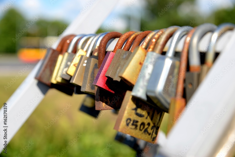Padlocks in love on the bridge on a sunny summer afternoon