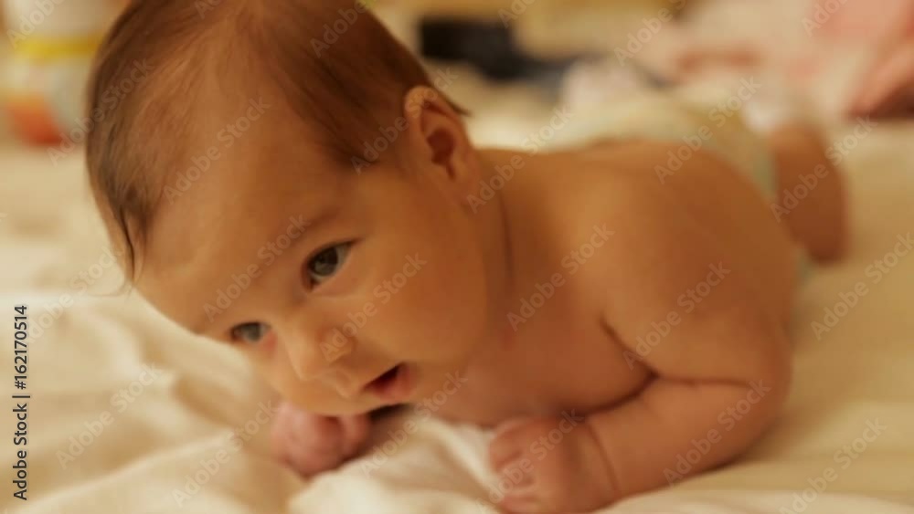 A newborn baby lies on the stomach A newborn baby lies on the stomach