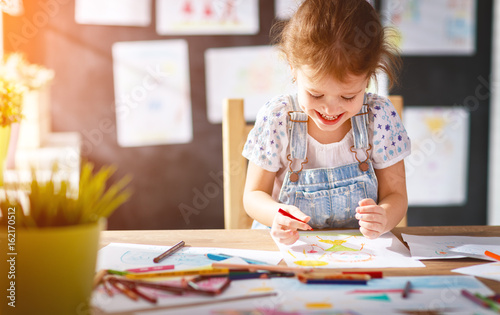 Obraz na plátne child  girl draws with colored pencils